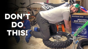 Mechanic struggling with bib mousse installation using Rabaconda tire changer in garage