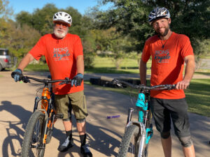 Father and son mountain bikers smiling