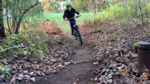 kid mountain biking on backyard trails