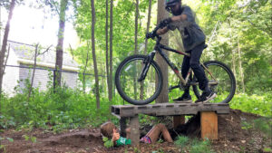 kid riding mountain bike on wooden feature