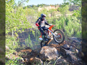 Dirt bike rider riding through a rock garden