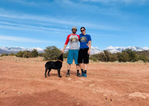 Man and women in front of a snow capped mountain range.