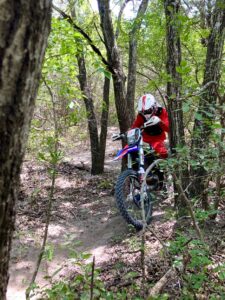 Dirt biker, back on the bike after time off, riding through tight singletrack.