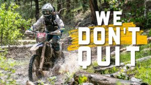 dirt bike rider splashing through a creek