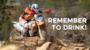A dirt bike rider looking exhausted on a hot day riding dirt bikes.