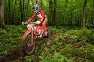 Enduro racer attacking a rocky, fern covered trail at the Rattlesnake Enduro in Pennsylvania.