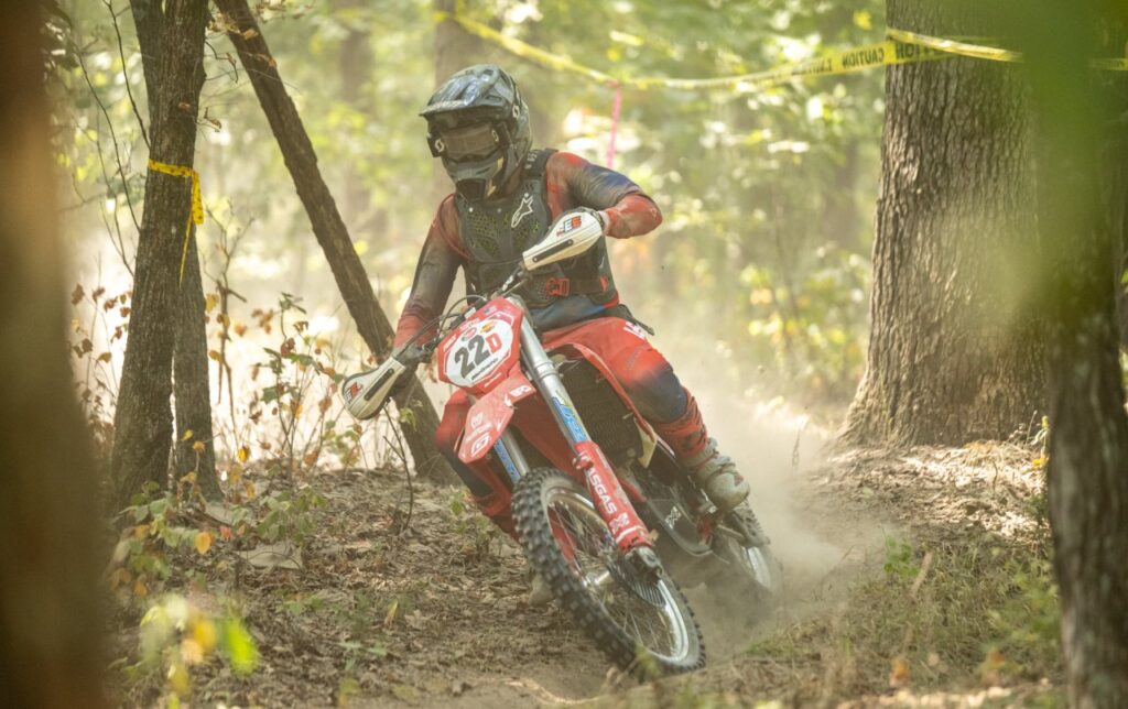 Brian Pierce riding a red GASGAS dirt bike through a dusty forest trail during the 2025 Leadbelt Enduro.